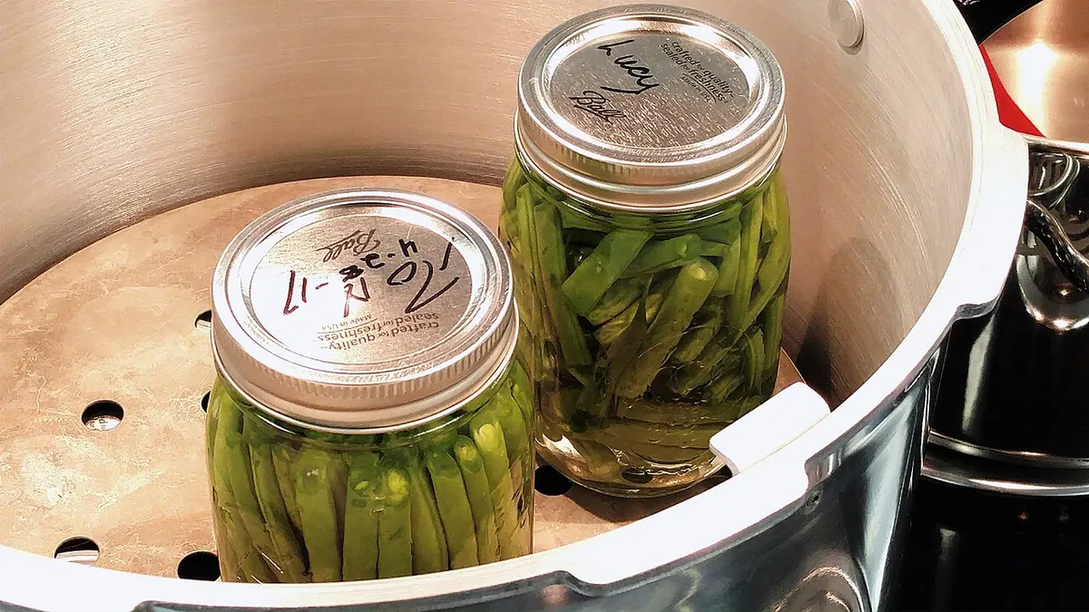 Jars of home-canned green beans loaded into a pressure canner